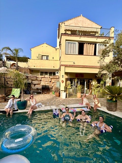 Guests in the pool in front of the house